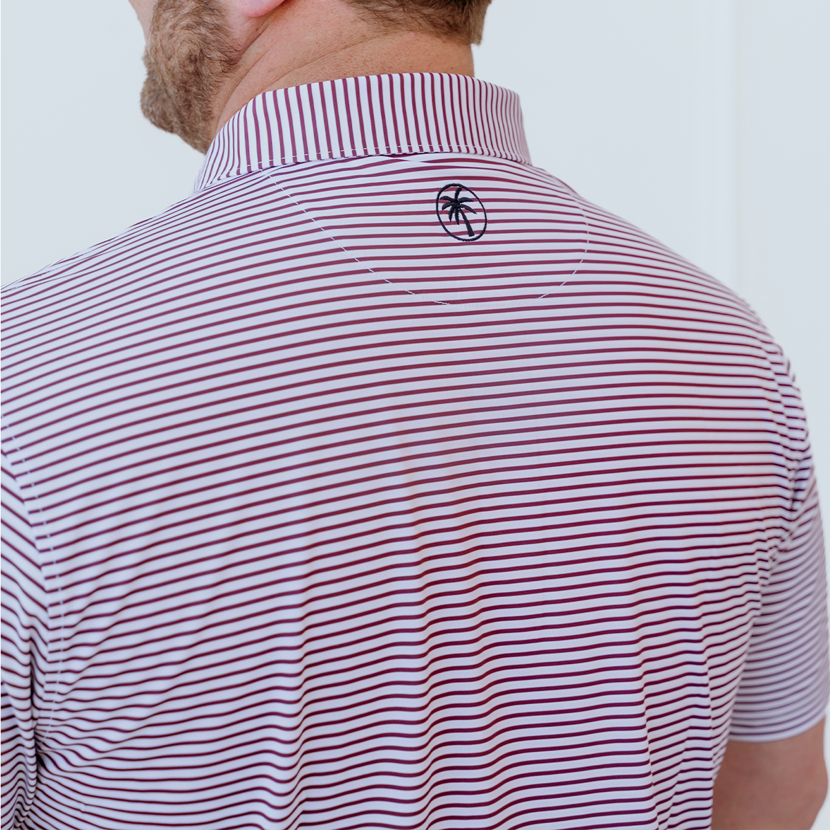 Back view of the Palmetto Clothing The Classic Stripe Polo in Garnet showcasing the tailored fit, breathable construction, and premium feel that define high quality golf shirts.
