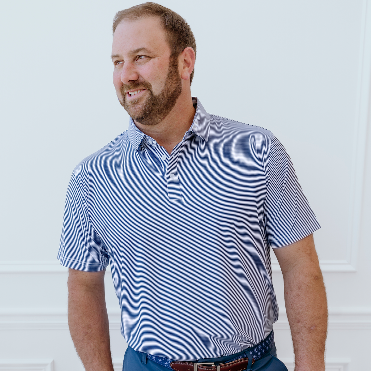 Model wearing the Palmetto Clothing The Classic Stripe Polo in Navy Blue, one of our premium breathable golf polo shirts featuring lightweight performance fabric and timeless striped style.