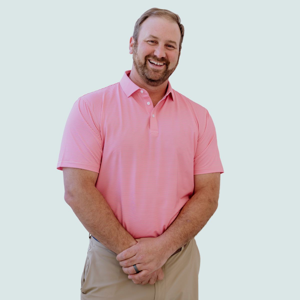 Model wearing the Palmetto Clothing The Classic Stripe Polo in Peach, one of our premium golf shirts designed for exceptional comfort and recognized as one of the best mens golf polo options for everyday wear.