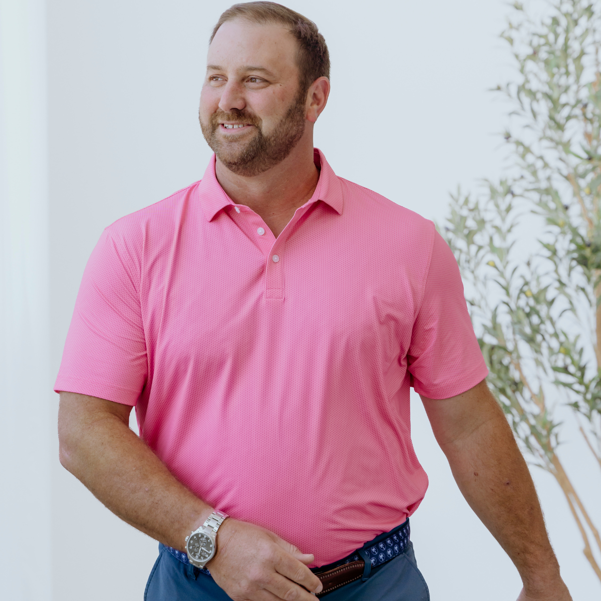 Model wearing the Palmetto Clothing The Hex Polo in Bright Pink featuring our signature geometric hex pattern. One of our premium performance golf shirts designed for golfers who appreciate bold style and exceptional comfort.