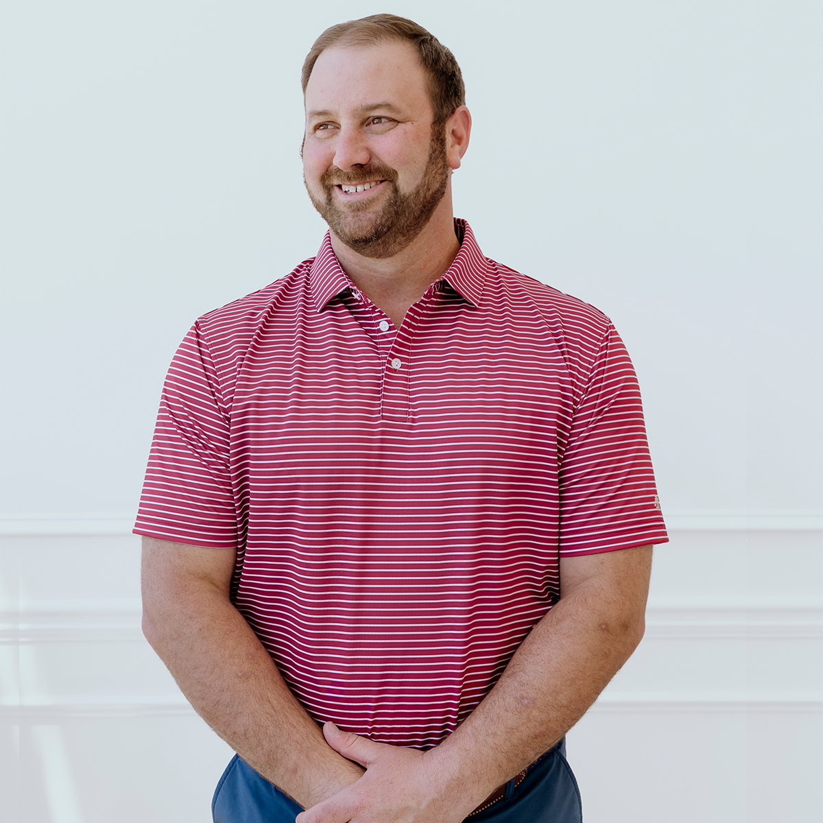 Model wearing the Palmetto Clothing The Anderson Polo in Persian Red featuring our signature stripe design. One of our premium breathable golf polo shirts, crafted with lightweight performance fabric and exceptional comfort for golfers on and off the course.