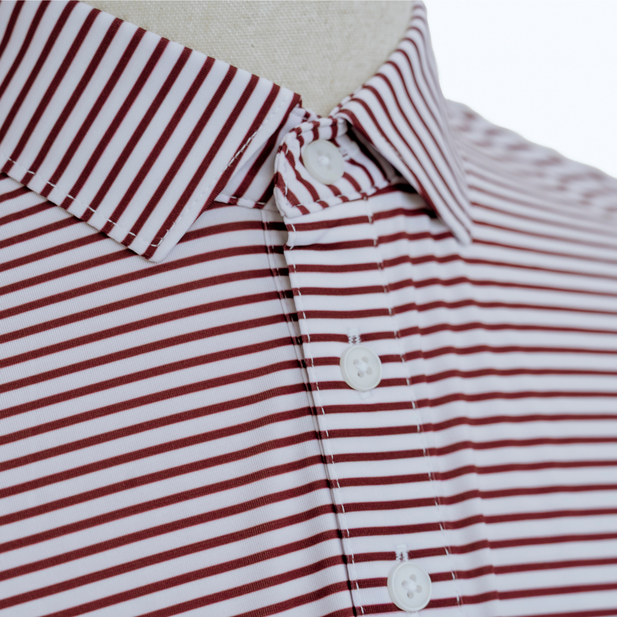 Close-up product detail of the Palmetto Clothing The Classic Stripe Polo in Garnet highlighting the premium fabric, refined craftsmanship, and elevated finish found in the best golf apparel.