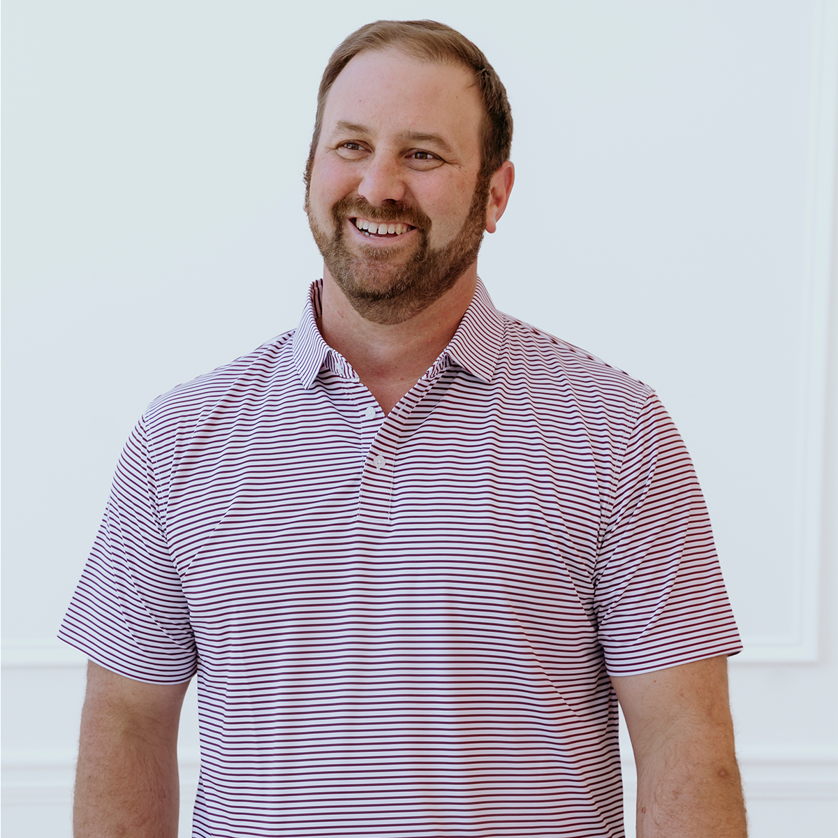 Front view of the Palmetto Clothing The Classic Stripe Polo in Garnet featuring a clean striped design and premium performance fabric. Part of our collection of the best golf apparel.