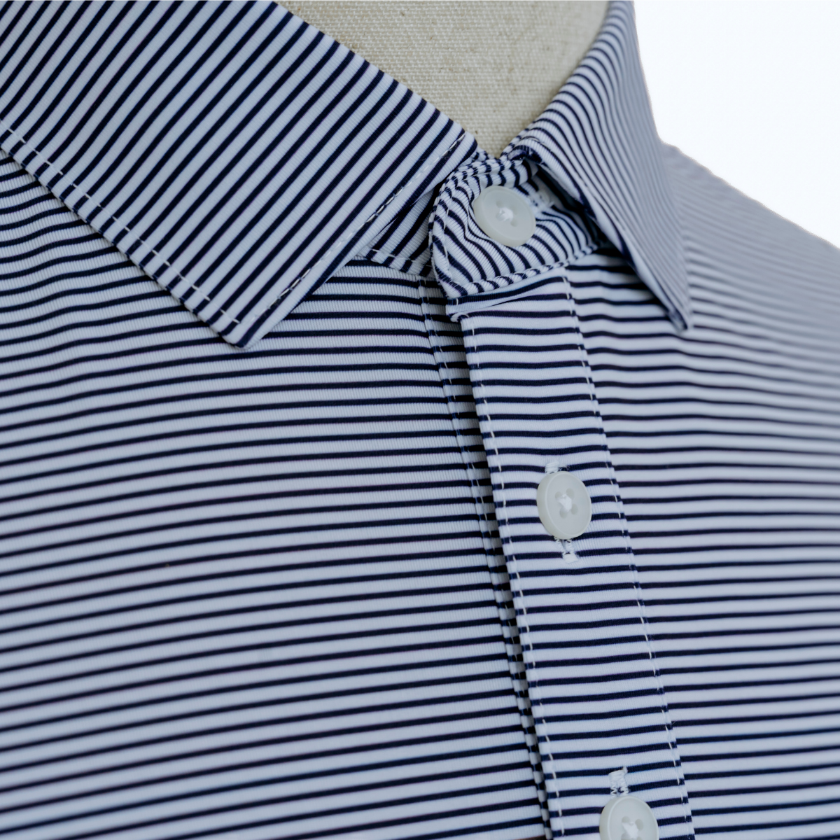 Close-up detail of the Palmetto Clothing The Classic Stripe Polo in Navy Blue featuring the soft performance fabric, premium stitching, and craftsmanship expected from performance golf polo shirts.