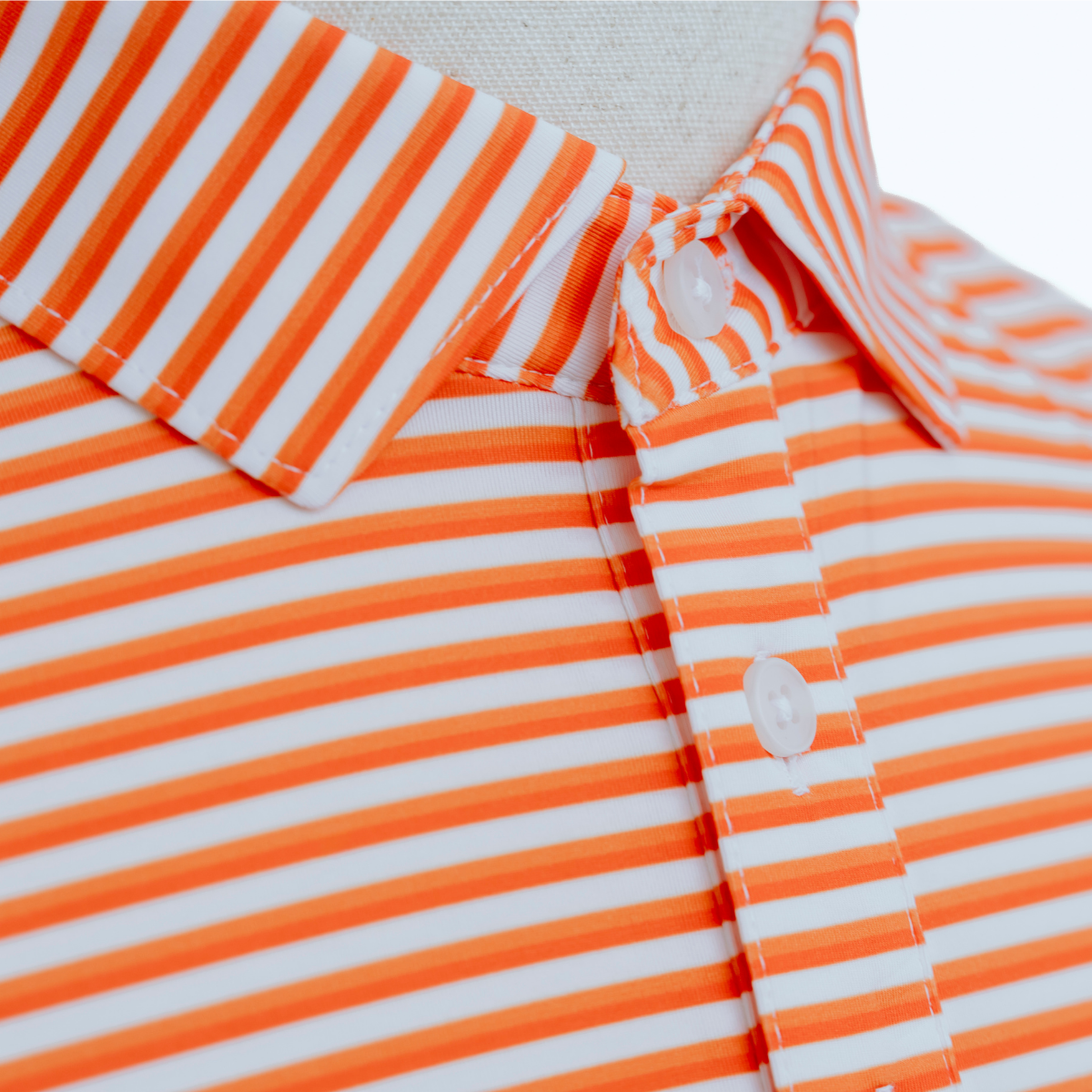 Close-up product detail of the Palmetto Clothing The Double Double Polo in Orange featuring the premium fabric, signature double stripe pattern, refined stitching, and craftsmanship that define our striped golf polos.