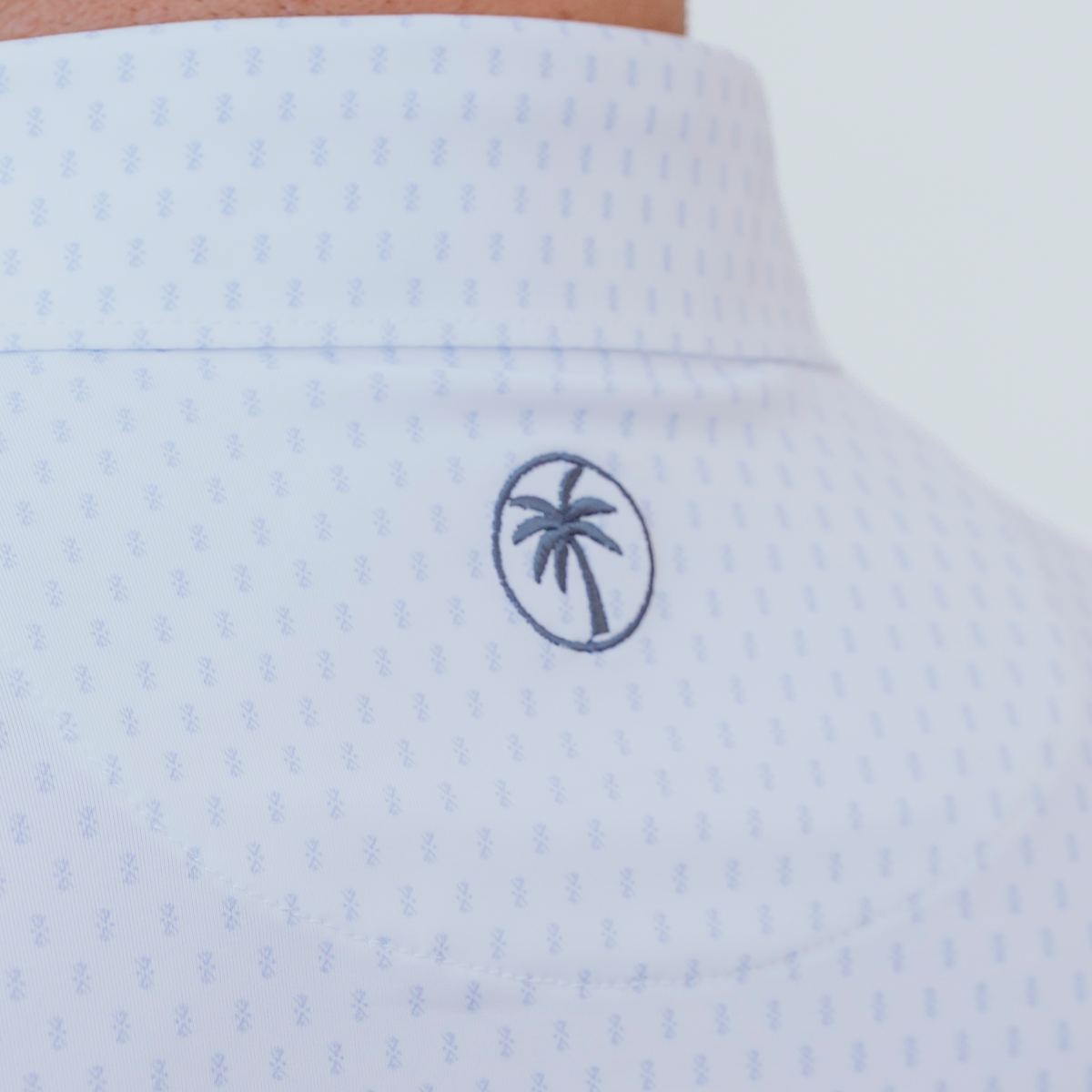Back view of the Palmetto Clothing The Flake Polo in White with Blue Flake pattern highlighting the athletic fit, breathable performance fabric, and lightweight construction built for golf and everyday wear.