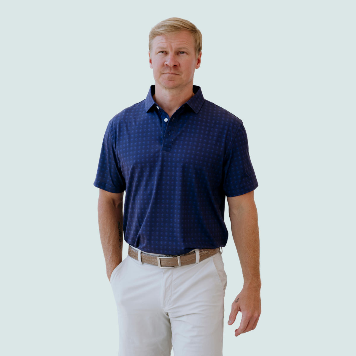 Model wearing the Palmetto Clothing The Icon Polo in Navy and Blue featuring our signature repeating logo pattern. One of our premium golf polos for men, combining breathable comfort with modern style and exceptional softness.