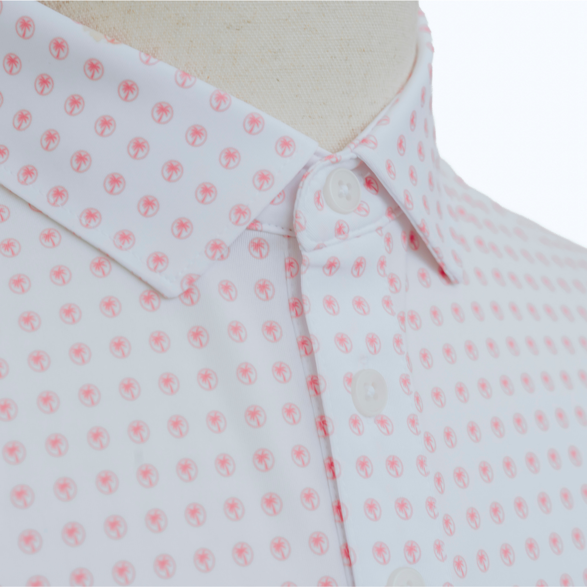 Close-up detail of the Palmetto Clothing The Icon Polo in White and Peach featuring the soft performance fabric, repeating logo pattern, premium stitching, and refined craftsmanship behind our golf polo shirts.