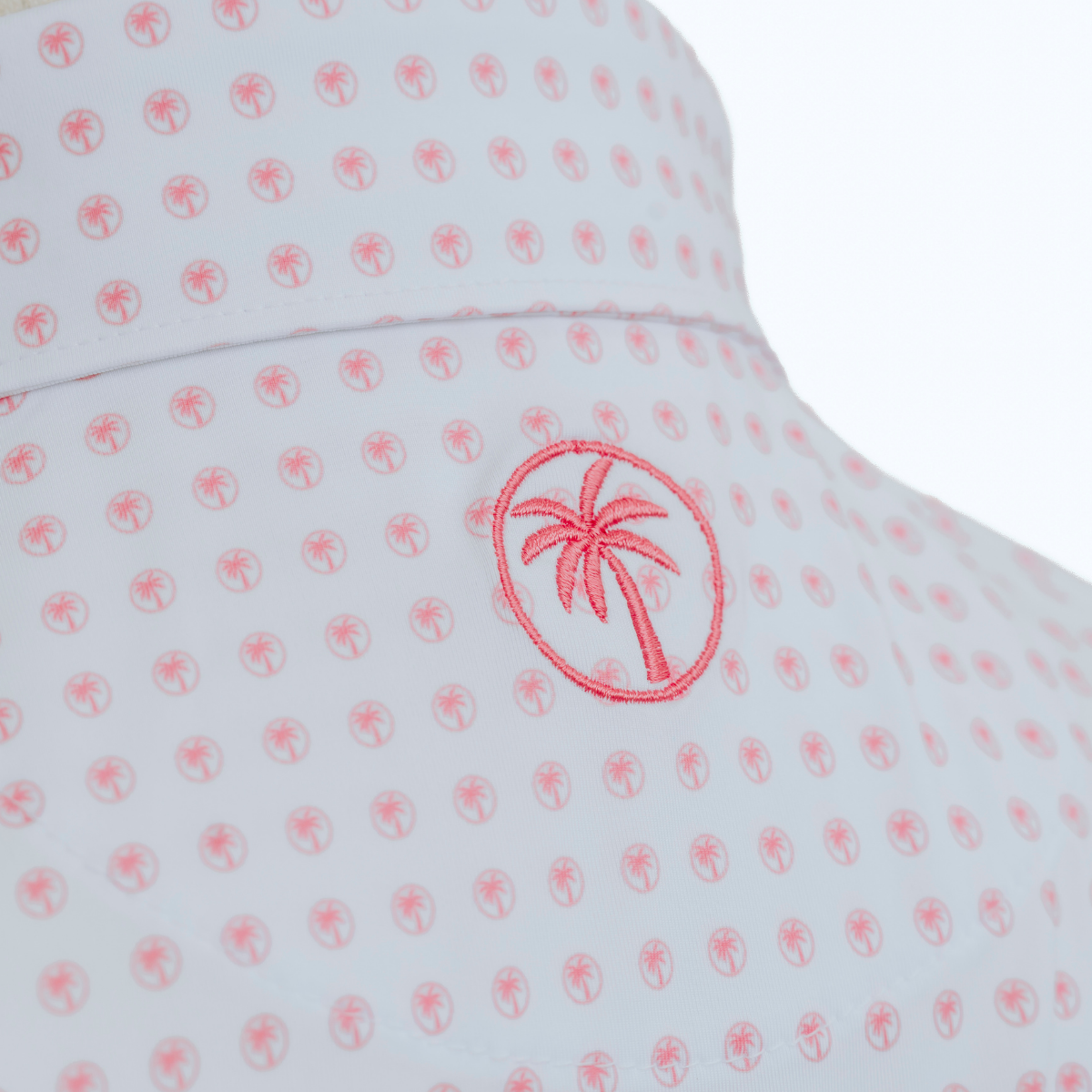 Close-up detail of the Palmetto Clothing The Icon Polo in White and Peach featuring the soft performance fabric, repeating logo pattern, premium stitching, and refined craftsmanship behind our golf polo shirts.