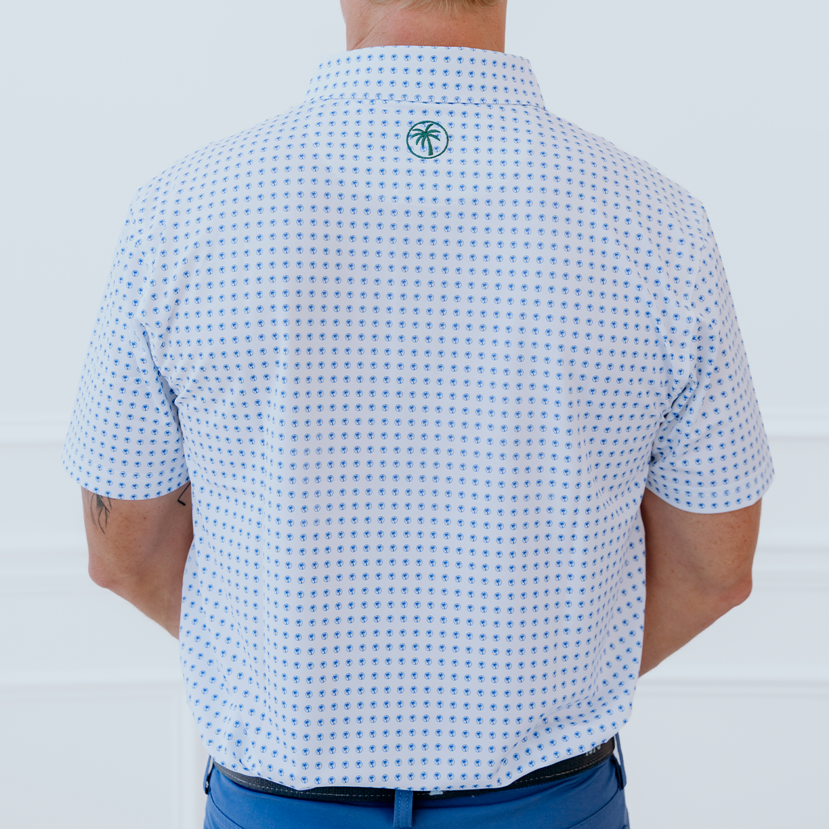 Back view of the Palmetto Clothing The Icon Polo in White and Bright Blue highlighting the athletic fit, breathable construction, and premium performance fabric designed for golf and everyday wear.