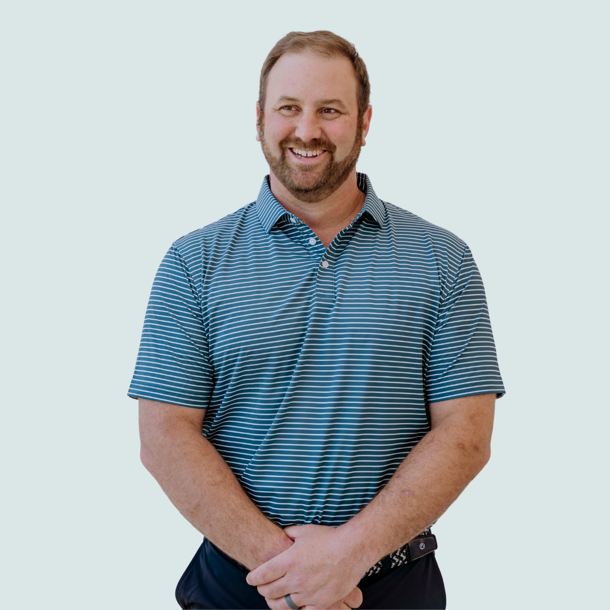 Model wearing the Palmetto Clothing The Anderson Polo in Aquamarine featuring a clean stripe pattern. A premium stripe golf polo designed with lightweight performance fabric and exceptional comfort for golf and everyday wear.