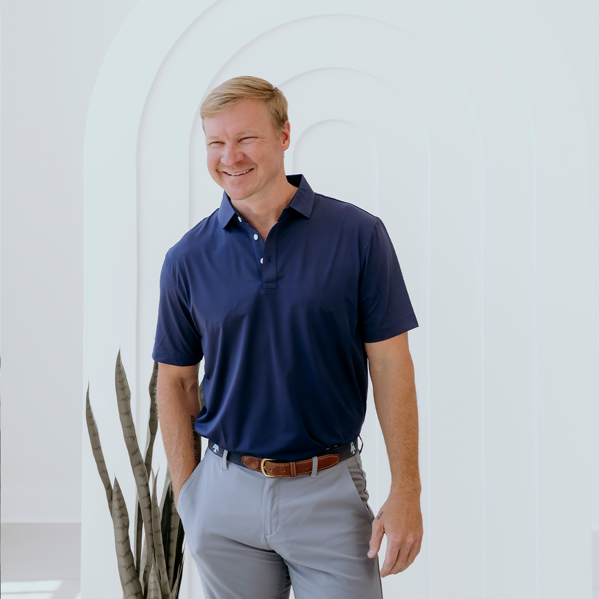 Model wearing the Palmetto Clothing The Wayne Polo in Navy, a premium navy blue golf shirt offering lightweight comfort, timeless style, and breathable performance for golfers on and off the course.