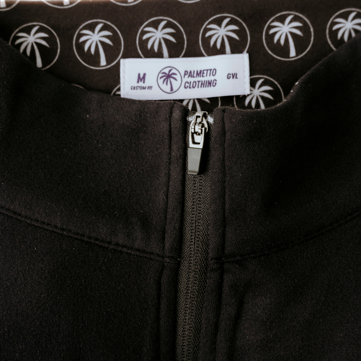 Close-up of the Palmetto Clothing Black Thomas quarter-zip featuring premium fabric, smooth zipper construction, and lightweight performance golf apparel craftsmanship.